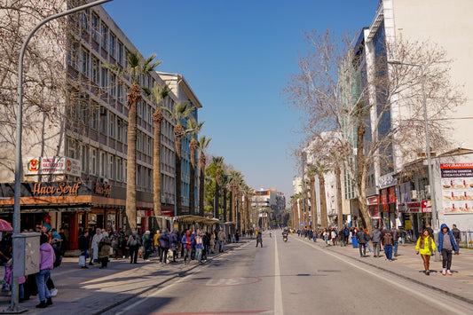 a group of people walking down a street next to tall buildings