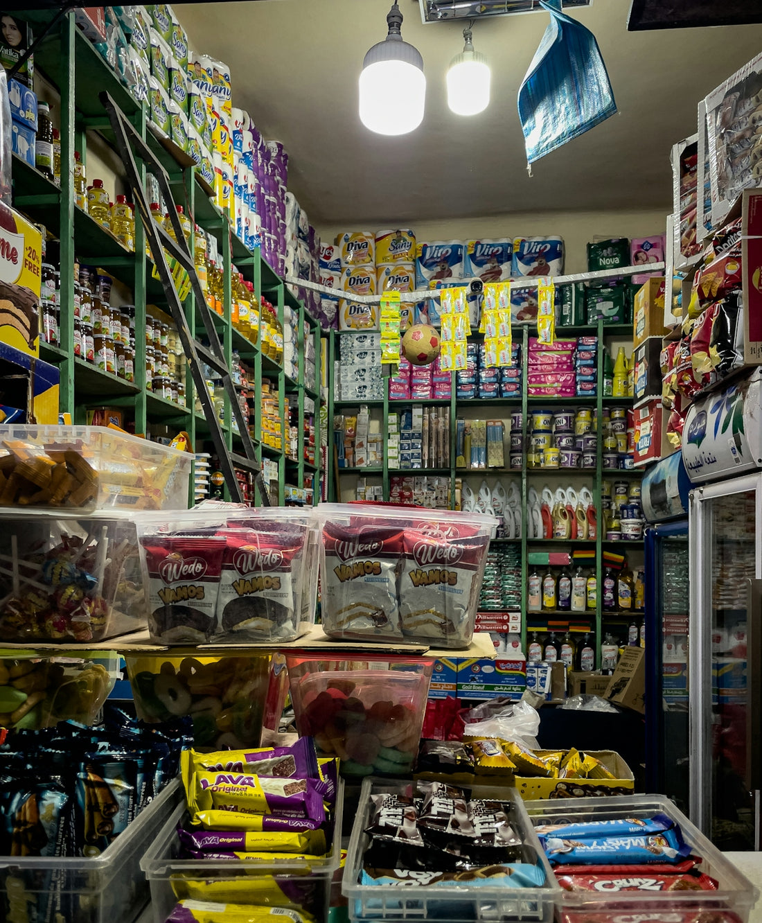 A small store aisle filled with snacks and goods