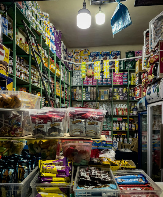 A small store aisle filled with snacks and goods