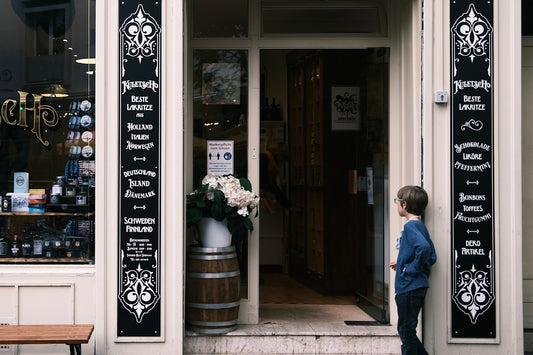 A young boy stands outside a shop entrance.