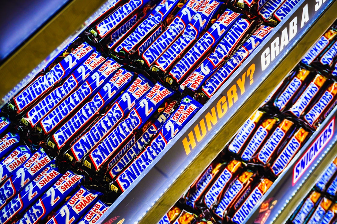Rows of snickers candy bars for sale.