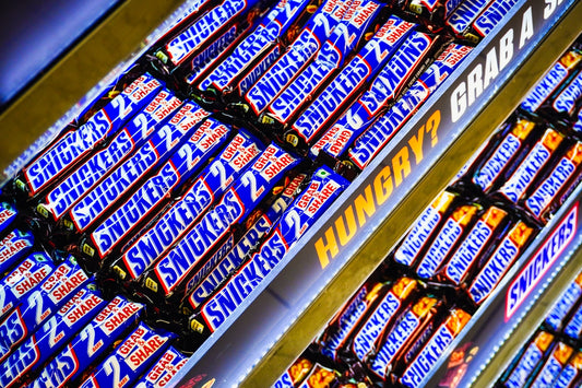 Rows of snickers candy bars for sale.