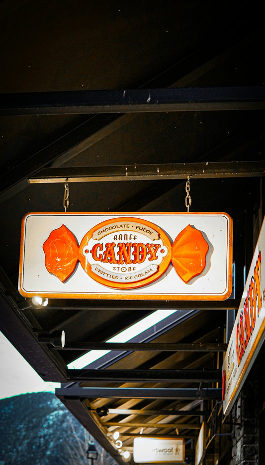 Vintage candy store sign shaped like an orange wrapped candy.