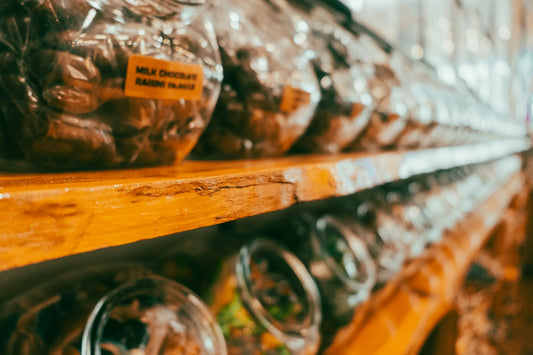 Rows of packaged sweets and treats on wooden shelves.